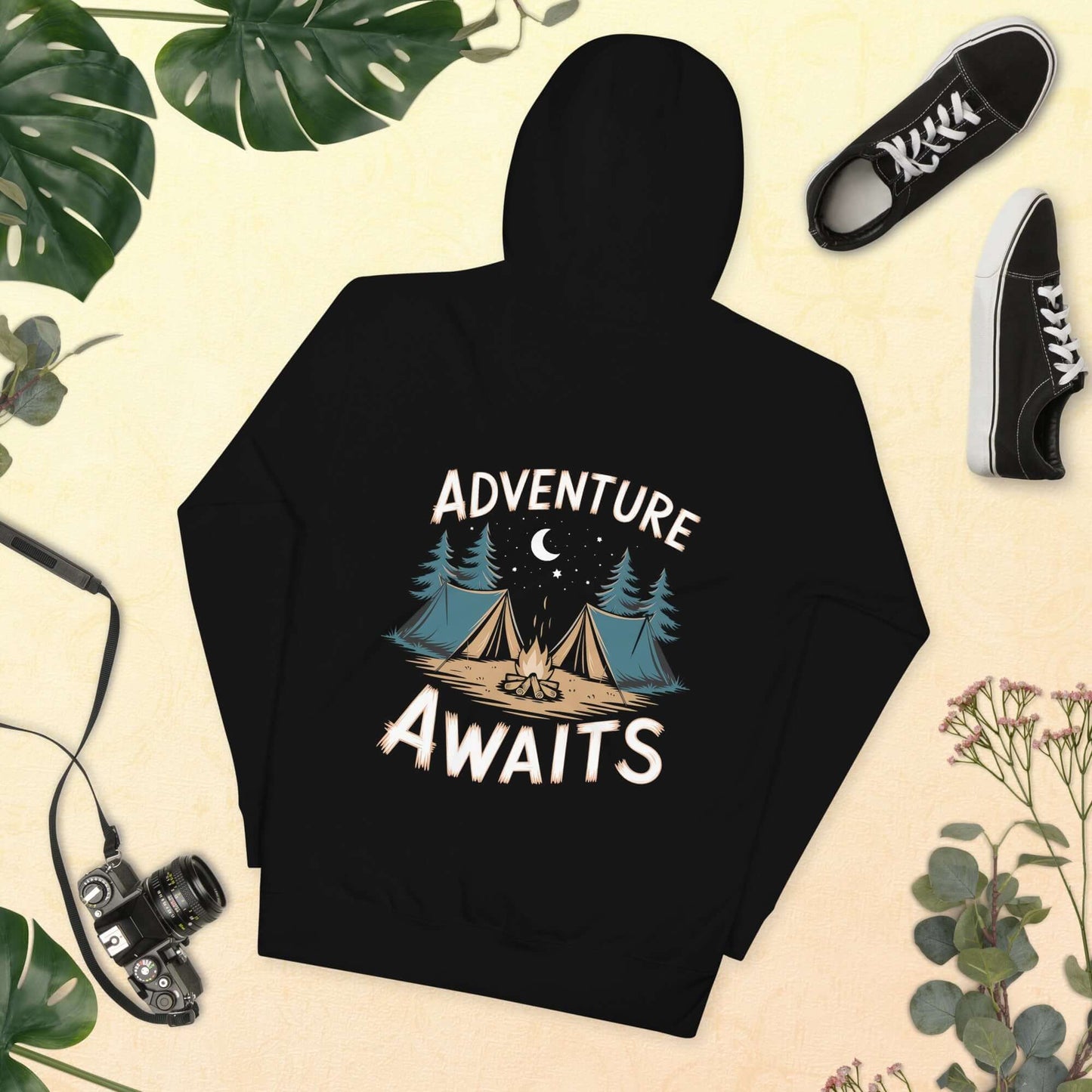 Black hoodie with 'Adventure Awaits' design featuring tents, trees, and a night sky, perfect for outdoor enthusiasts.