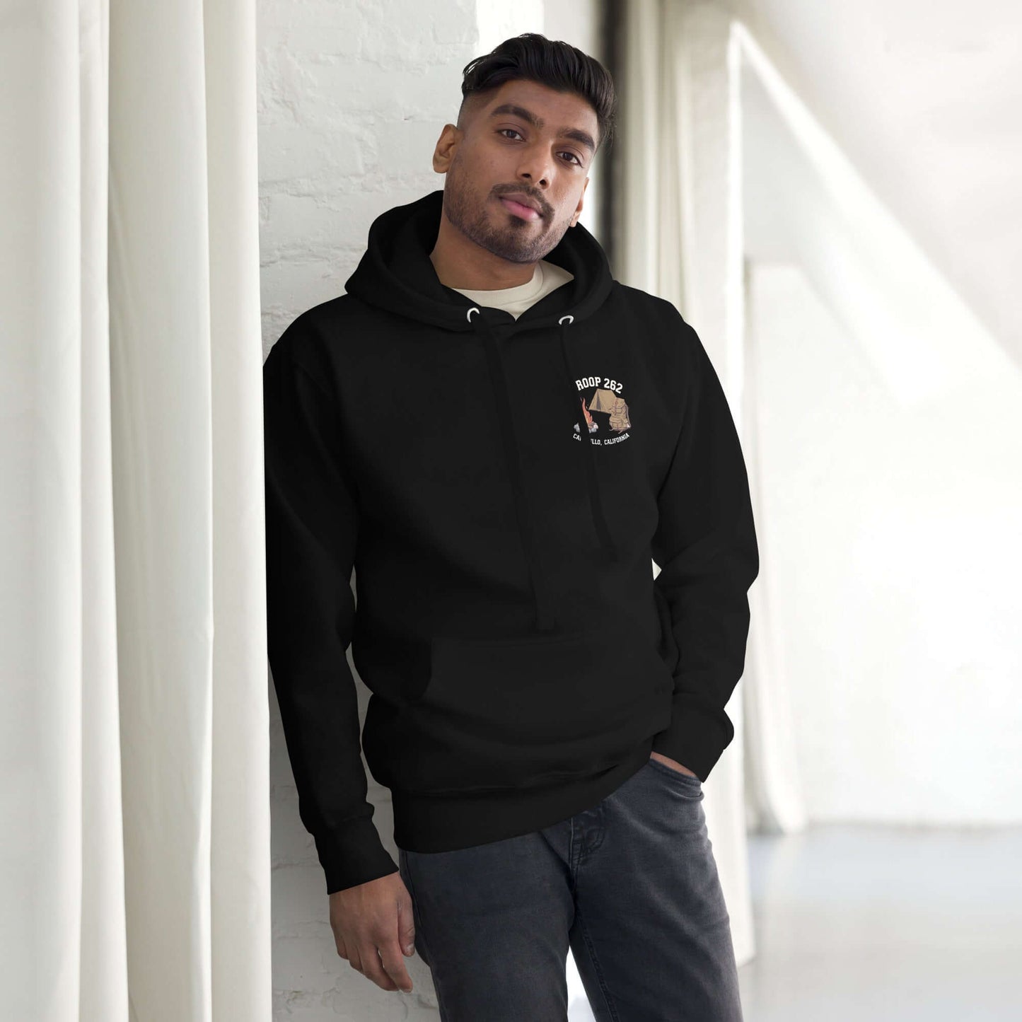 Adult Unisex Hoodie in black, showcasing Troop 262 logo, worn by a man in a modern indoor setting.