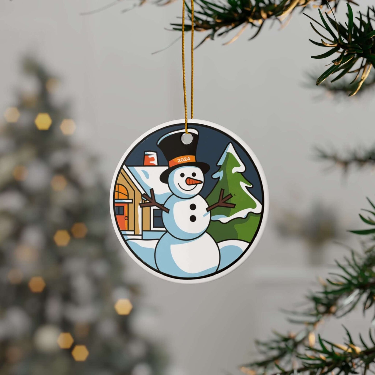 Charming snowman ceramic ornament hanging on Christmas tree with festive scene of a house and tree in the background.