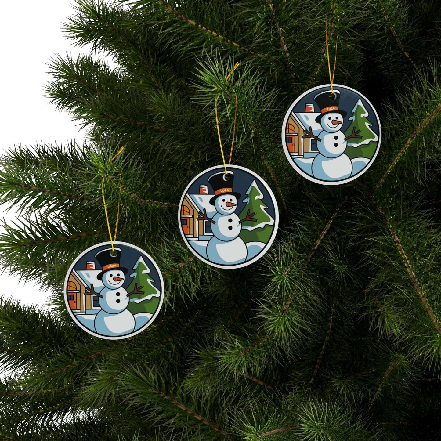 Ceramic ornaments with snowman holiday scene hanging on Christmas tree branches.