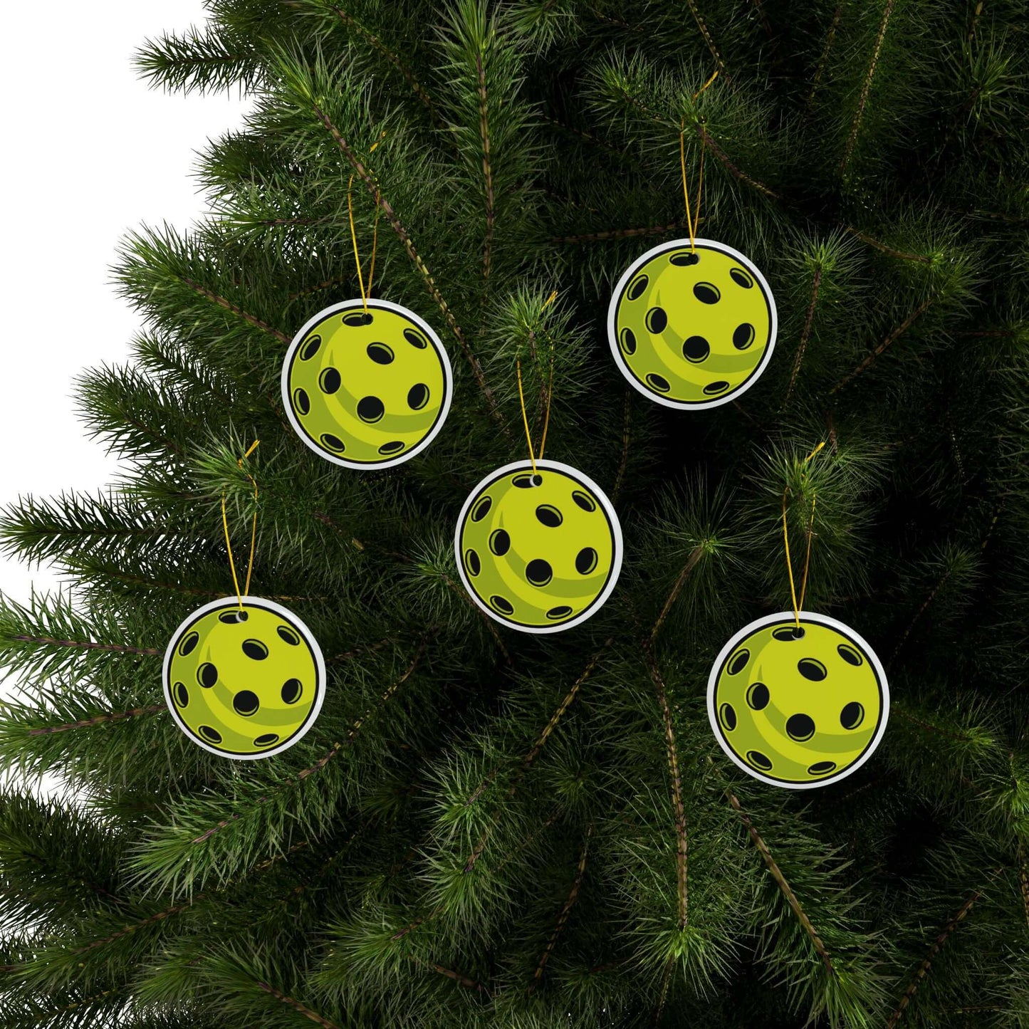 Pickleball Christmas ornaments with vibrant print hanging on a tree, perfect holiday decor for pickleball enthusiasts.