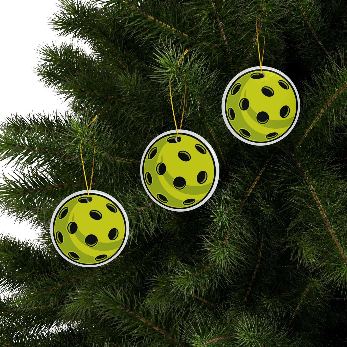 Pickleball Christmas ornaments hanging on a tree, featuring vibrant two-sided print and glossy ceramic finish.