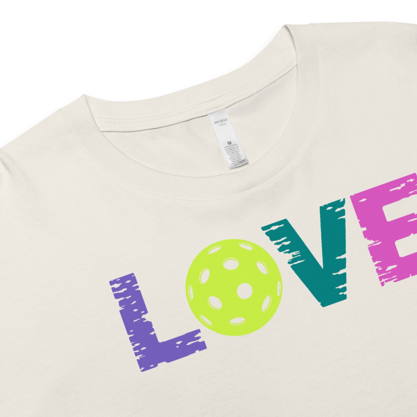 Close-up of Women’s LOVE Pickleball Crop Top featuring colorful text and a pickleball graphic.