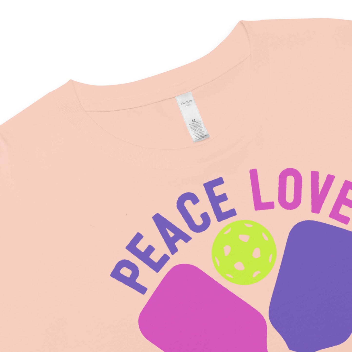 Close-up of Women's Peace, Love, Pickleball Crop Top, showcasing vibrant design with paddles and a ball.