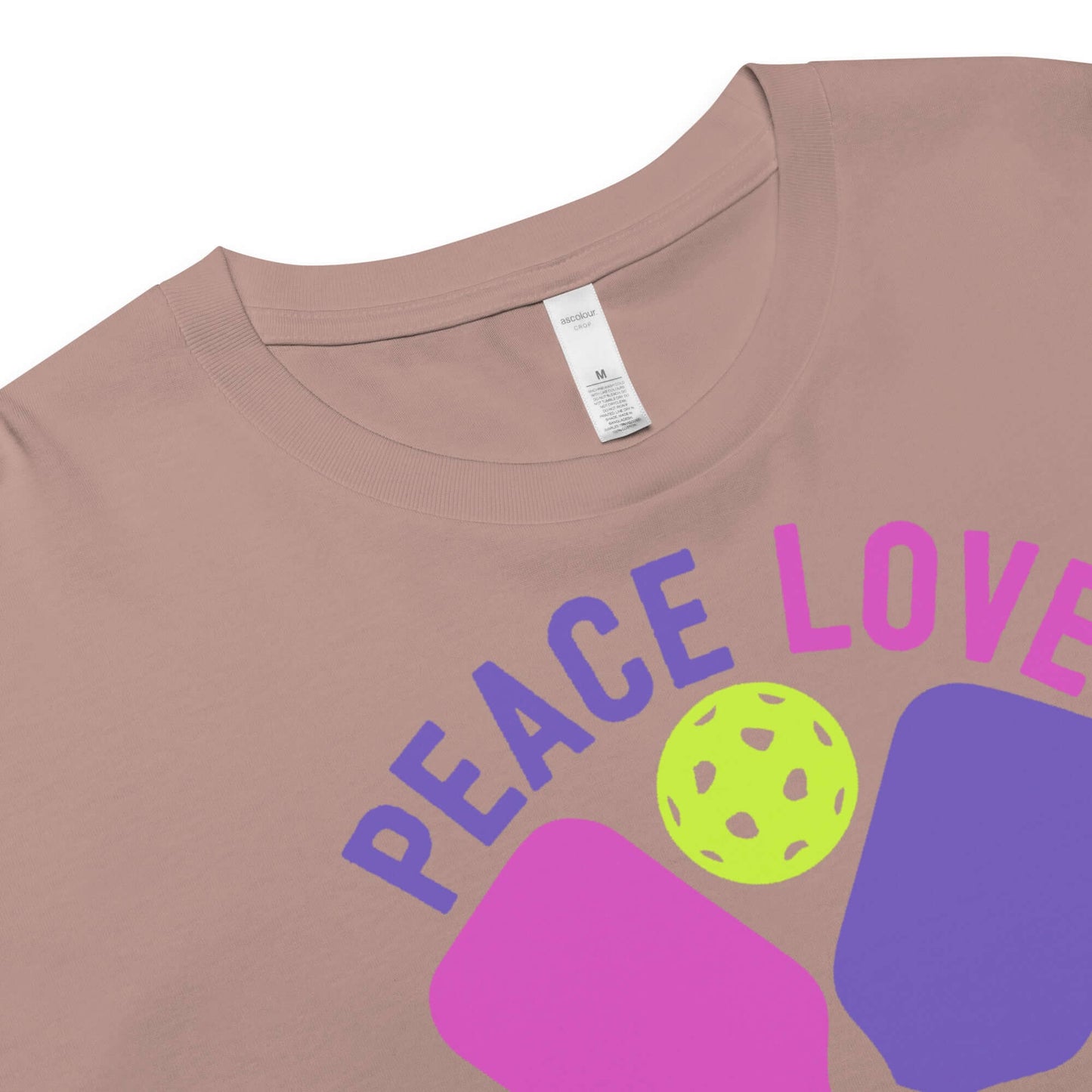Close-up of Women's Peace, Love, Pickleball Crop Top, featuring colorful graphic design on a light background.