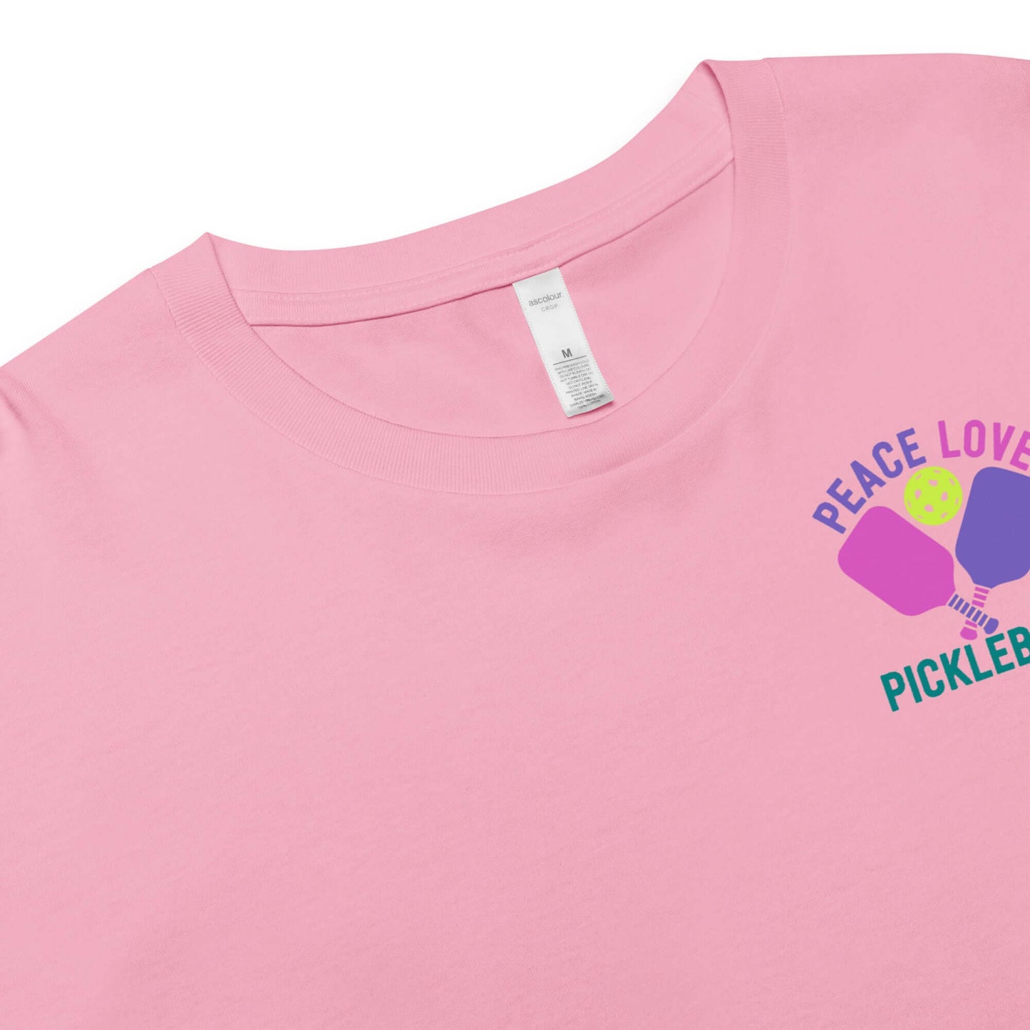 Women's pink crop top featuring "Peace Love Pickleball" graphic design.