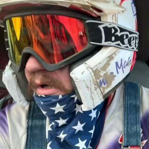 Person wearing BEER Optics goggles with reflective lenses and a star-pattern bandana for dust protection and comfort.