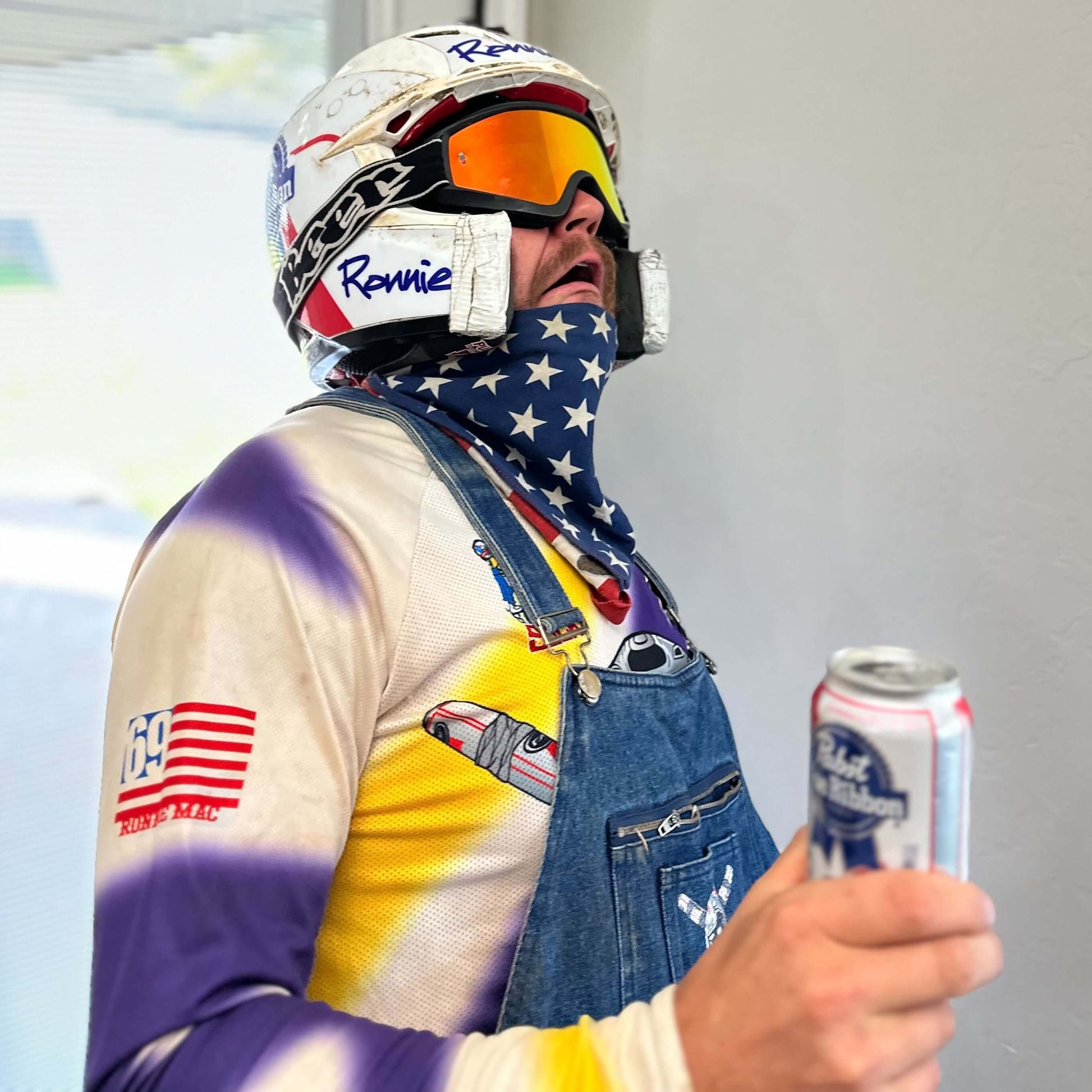 Person wearing "Beer Goggles" with reflective lenses, star-patterned bandana, and holding a beverage can, showcasing outdoor style.