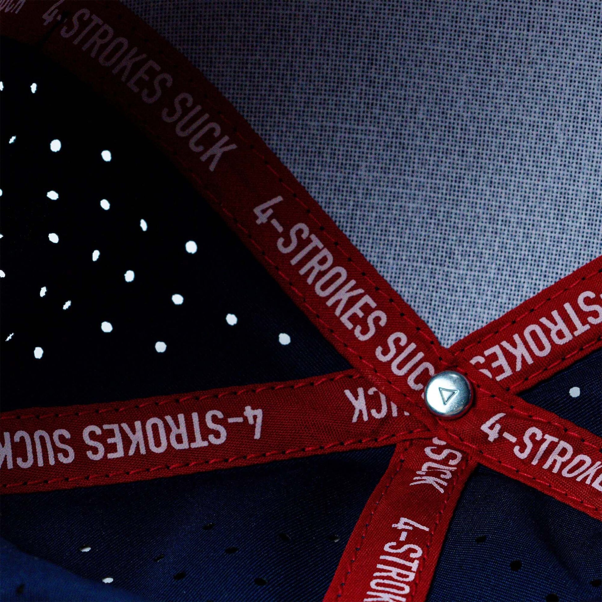 Close-up of Crossbones Helmet Laser Cut Signature Hat interior showing red straps with "4-Strokes Suck" text.