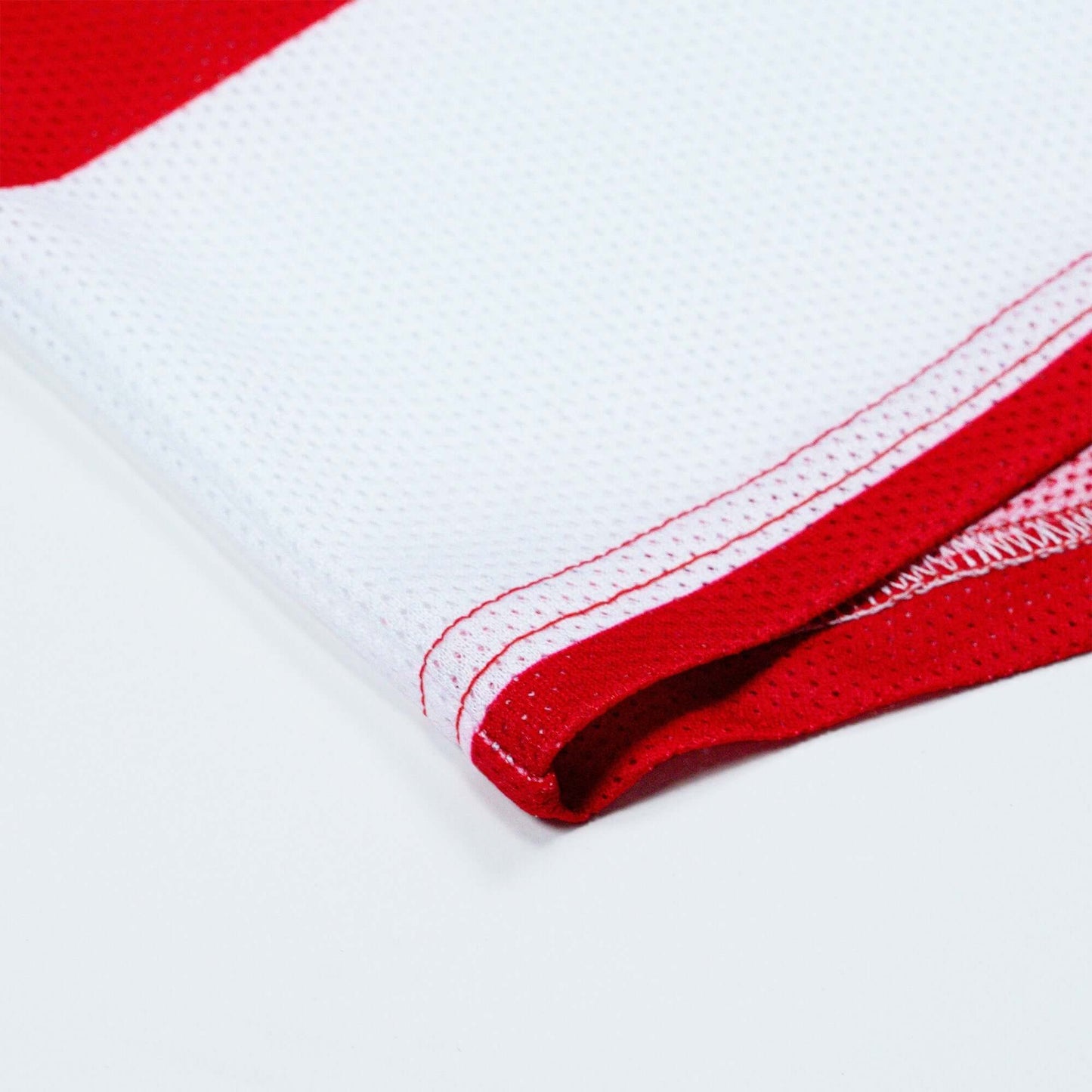 Close-up of red and white Crossbones Merica Jersey showcasing the vented polyester mesh fabric and precise stitching.