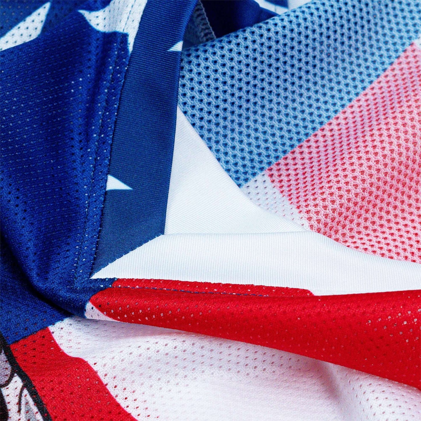 Close-up of the Crossbones Merica Jersey fabric featuring blue, red, and white mesh design with star patterns, highlighting its texture.