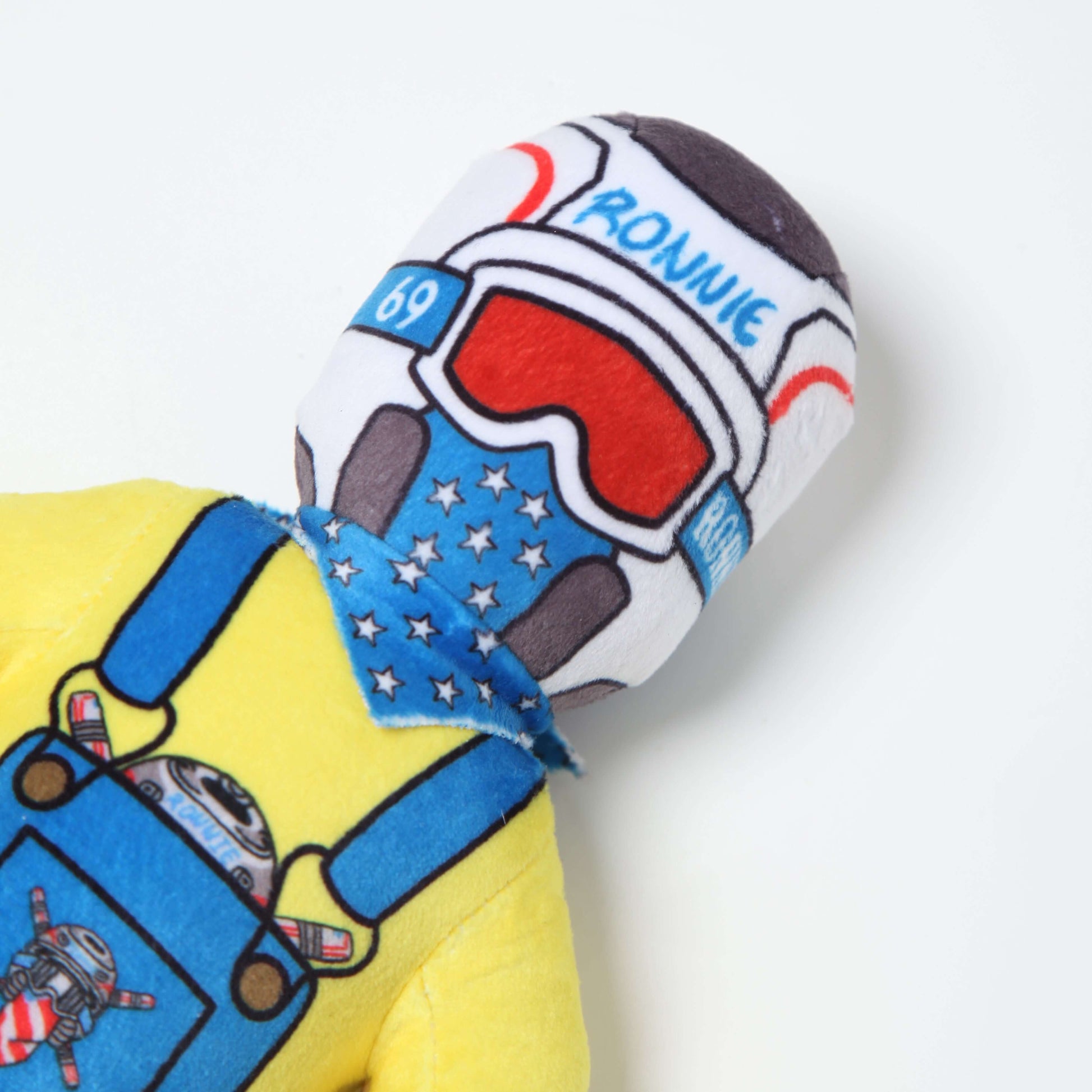 Lil Ronnie plush toy in colorful overalls and helmet with stars, embodying a mischievous yet charming character.