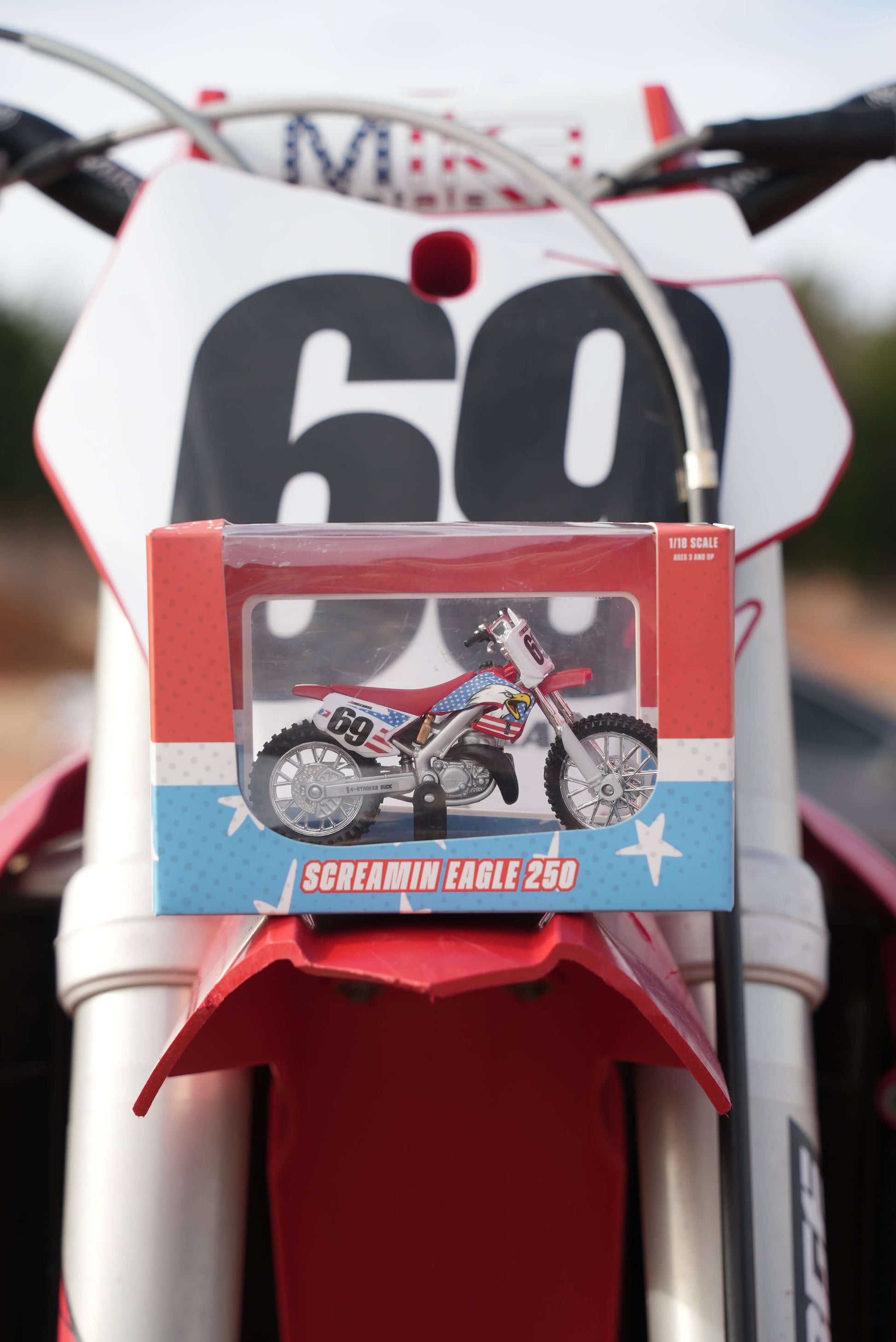 "Screamin Eagle 250 Replica Collectible Dirt Bike toy displayed on a motocross bike"