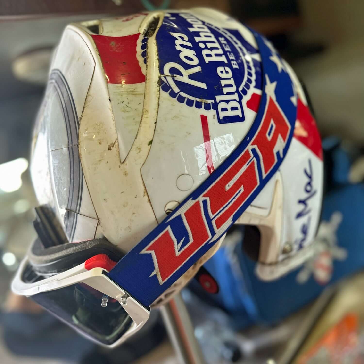 USA Merica Goggles with Oakley lens on helmet displaying patriotic design, featuring USA on side, ideal for racing enthusiasts.