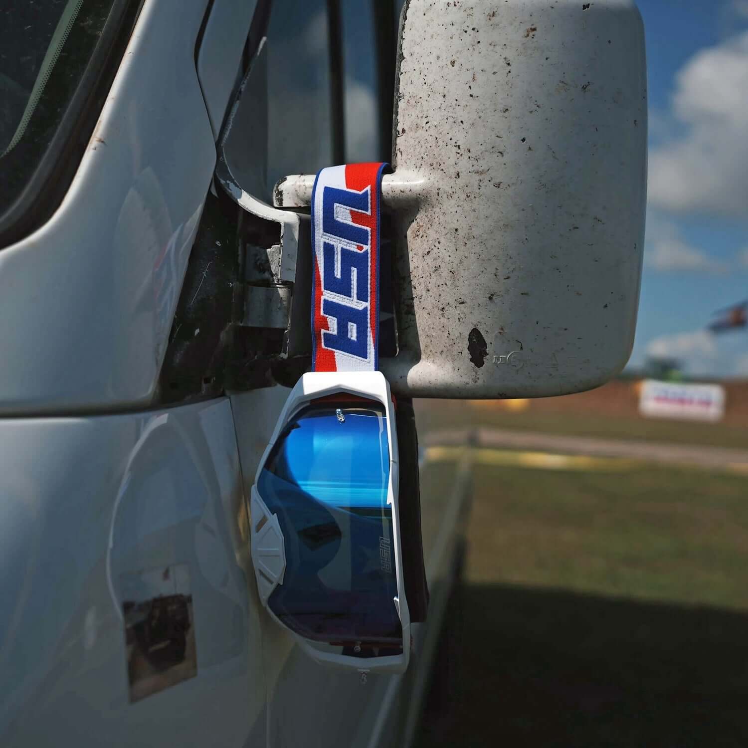 USA Merica Goggles with Oakley Dry Break lens hanging on vehicle mirror, featuring bold USA design. Perfect for clear vision.