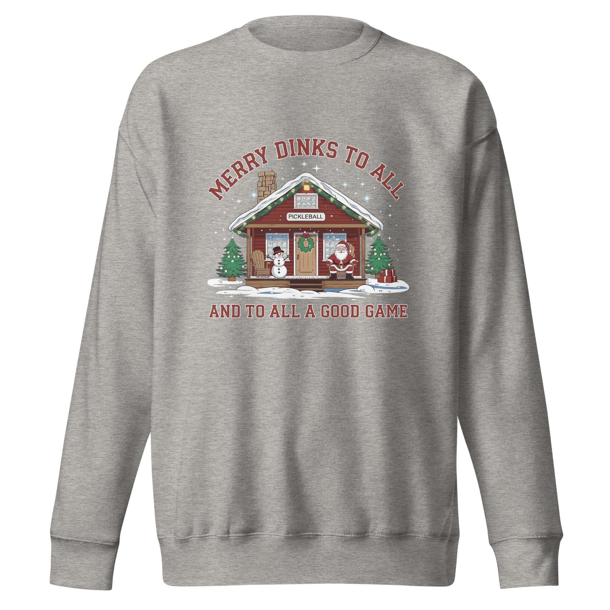 Cozy Merry Dinks holiday sweatshirt featuring a pickleball cabin, festive snowman, Santa, and Christmas trees under a starry sky.