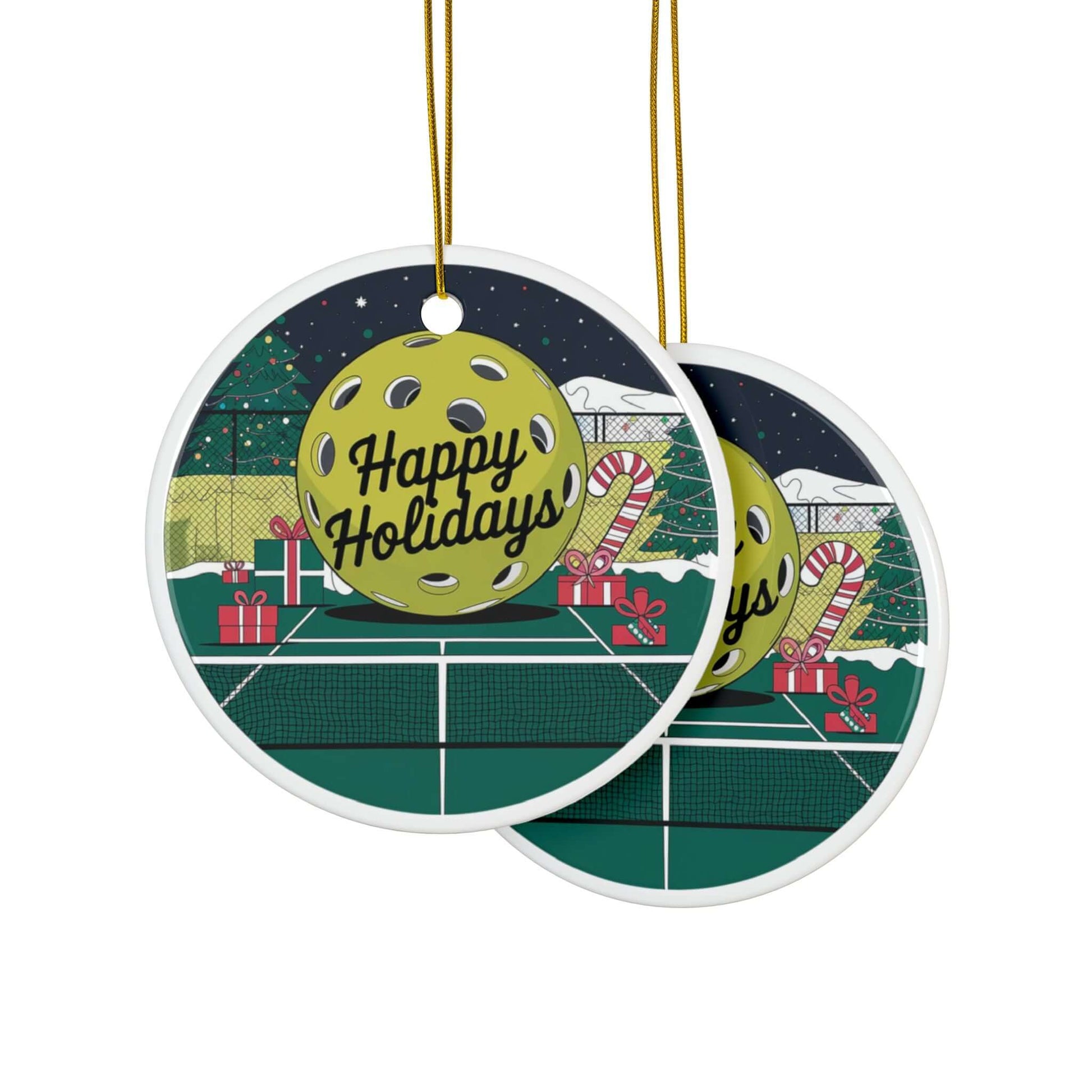 Pickleball holiday ceramic ornaments with "Happy Holidays" text, featuring a festive court scene with Christmas tree and candy canes.