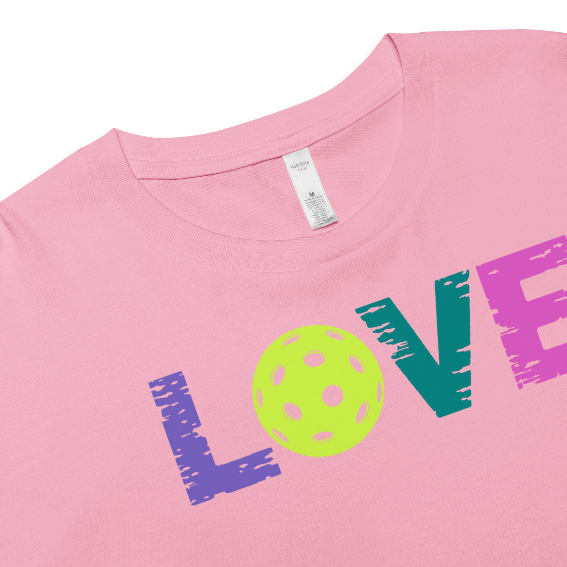 Close-up of Women’s LOVE Pickleball Crop Top in pink, featuring colorful letters and a pickleball graphic.