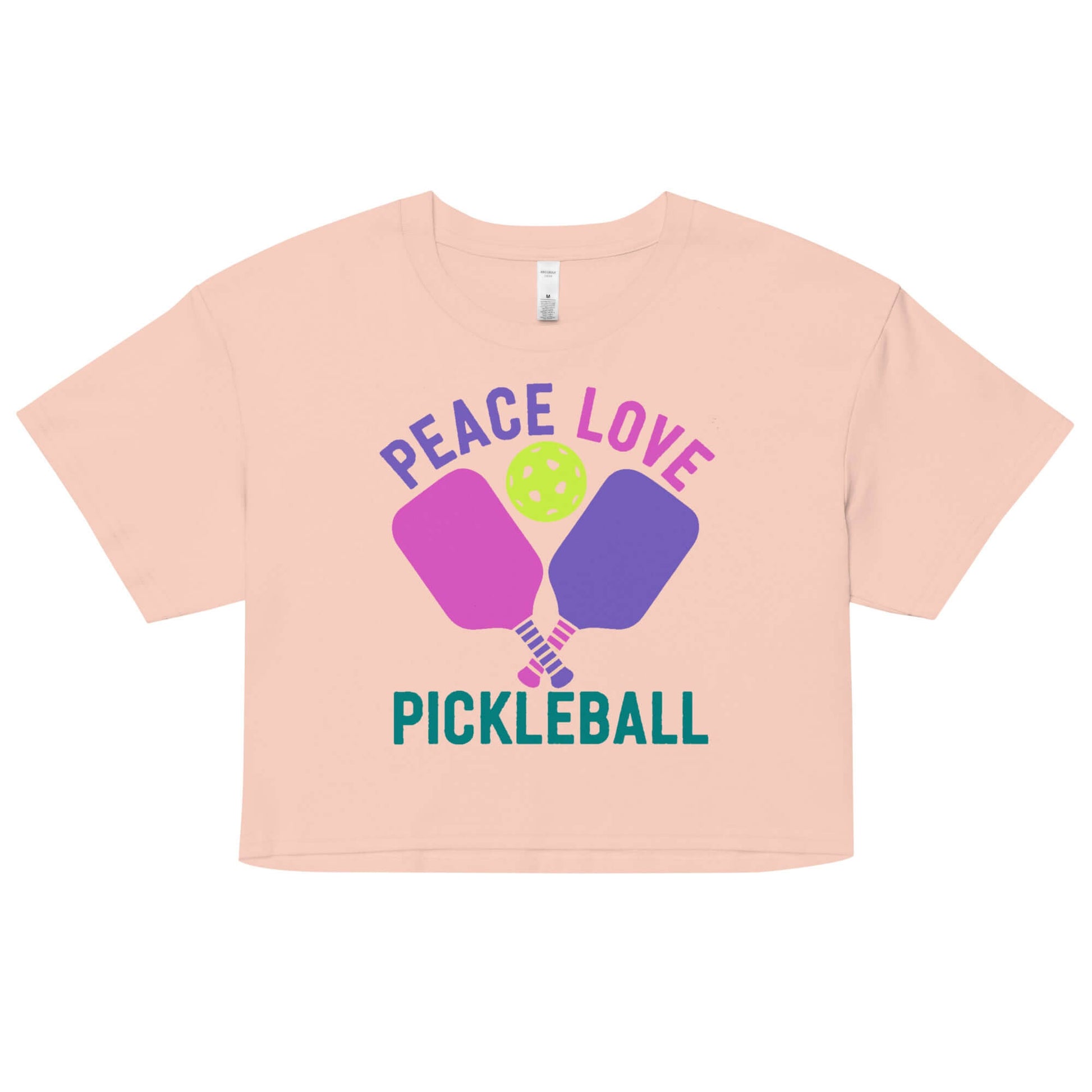 Women’s Peace, Love, Pickleball Crop Top with vibrant design and pickleball paddles in soft peach color.