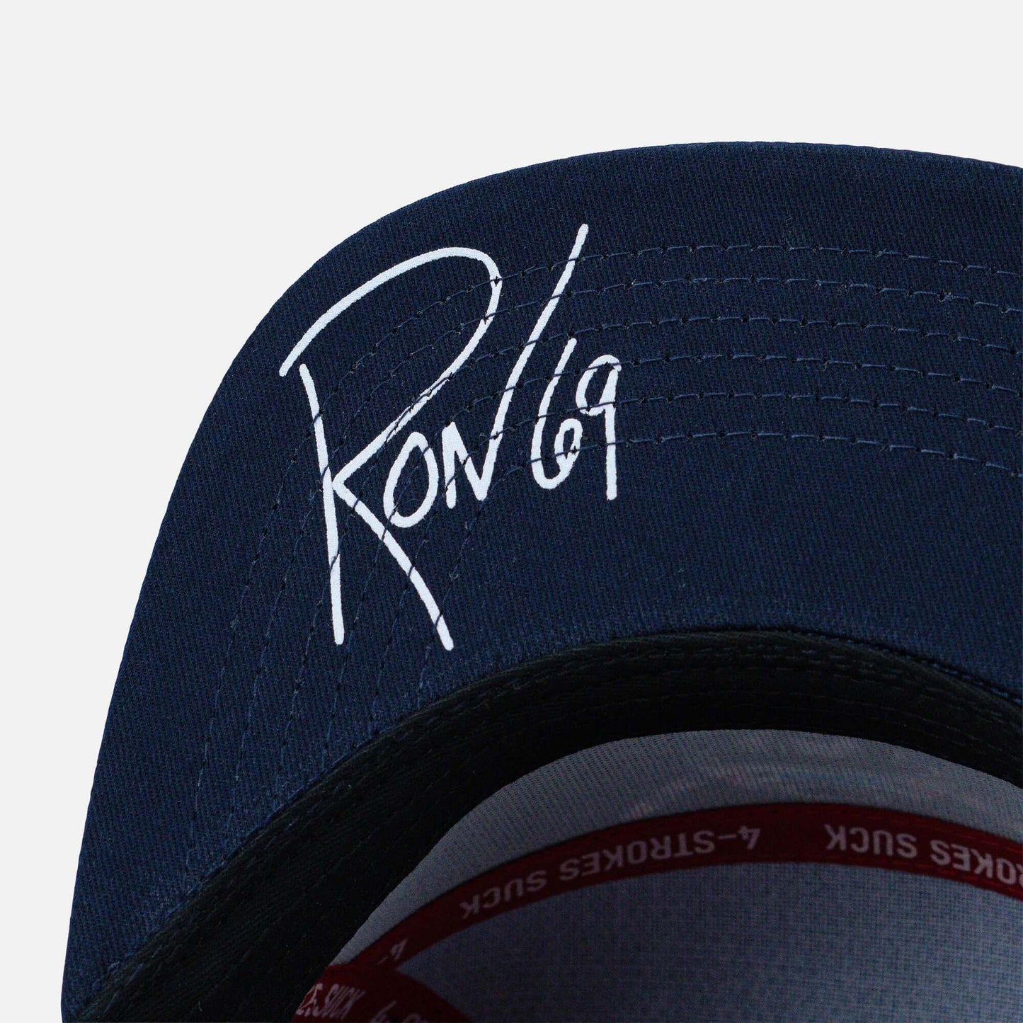 Crossbones Helmet Laser Cut Signature Hat with white signature detail on navy fabric, featuring moisture-wicking polyester material.