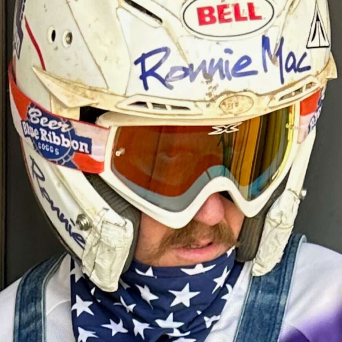 Person wearing Blue Beer Ribbon Goggles and a helmet with face covering, ideal for moto and bike activities.